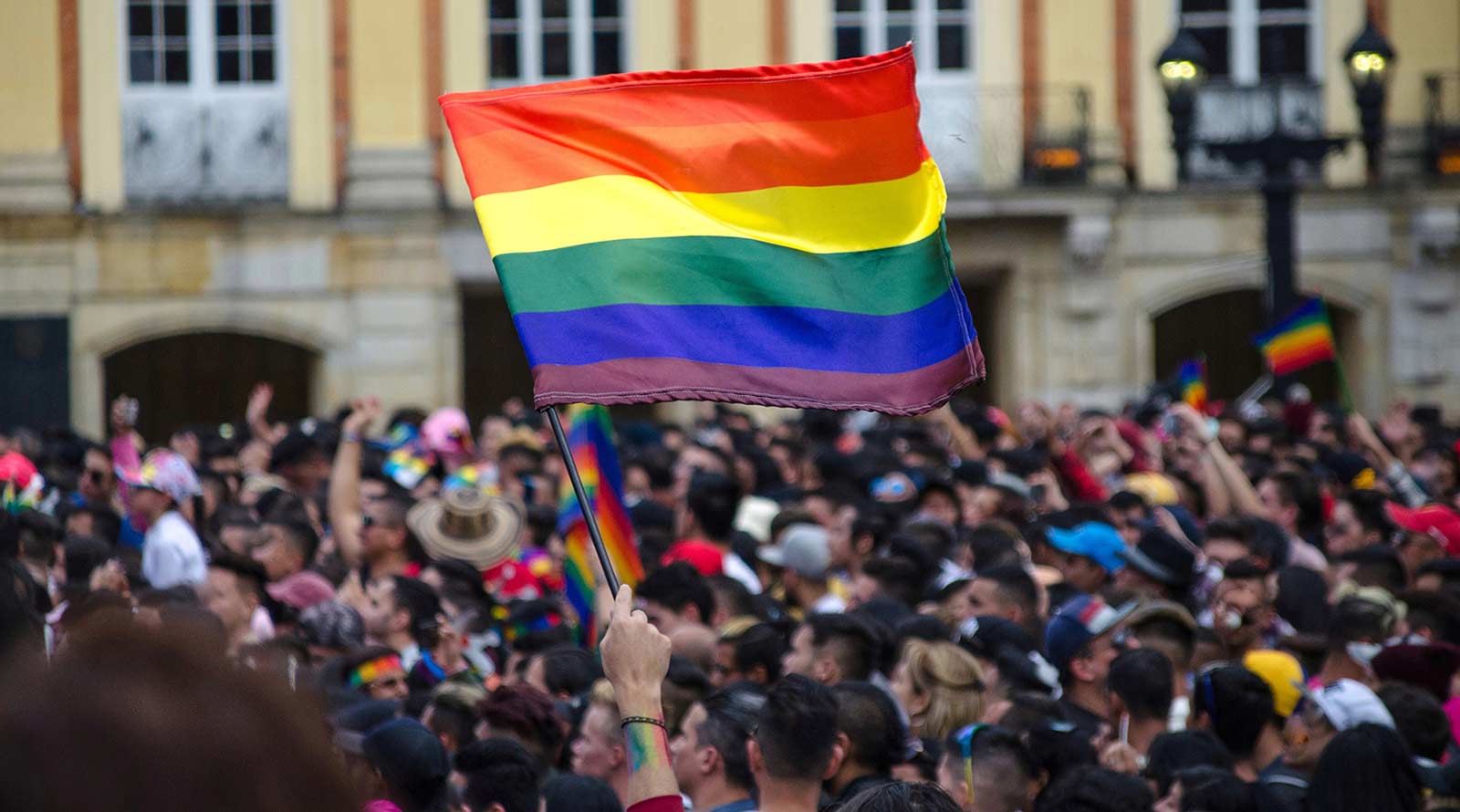 Rainbow Flag in crowd against building