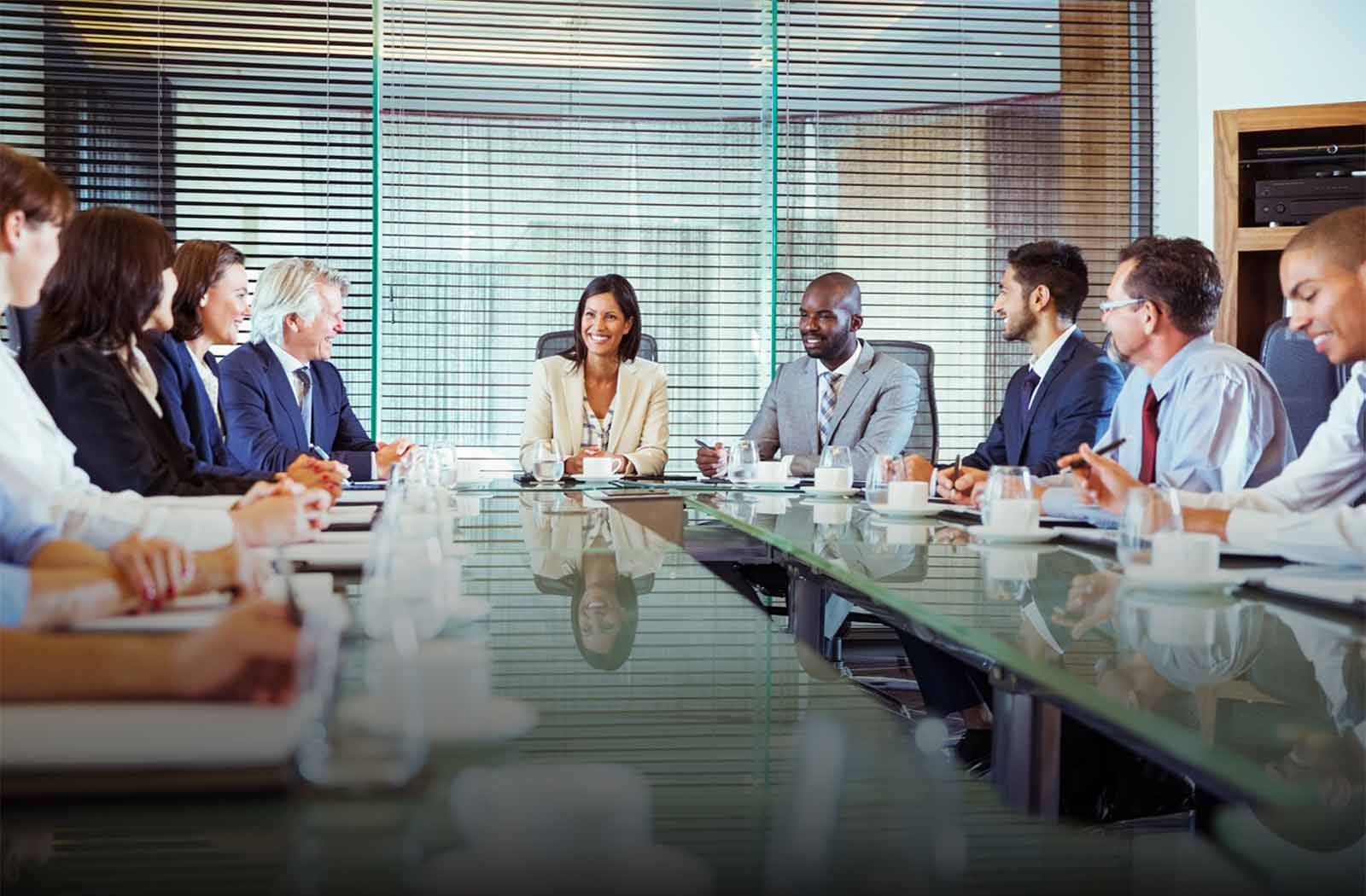 Business people having meeting in a conference room, smiling and discussing