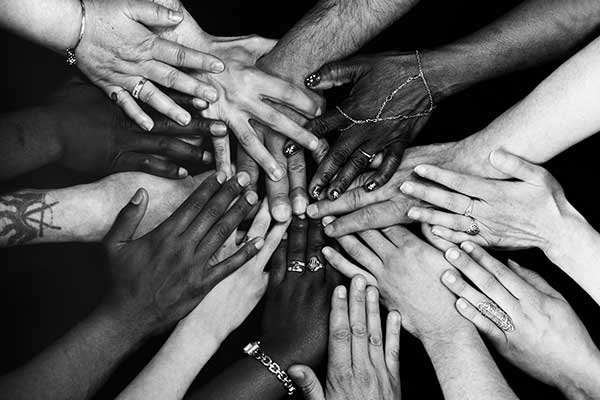 Male and female hands of various ethnicities all together. Monochrome.